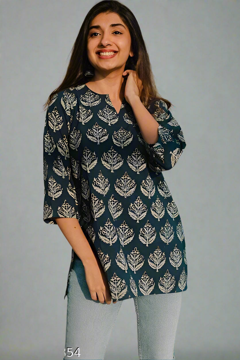 Woman wearing a dark blue patterned top against a plain background